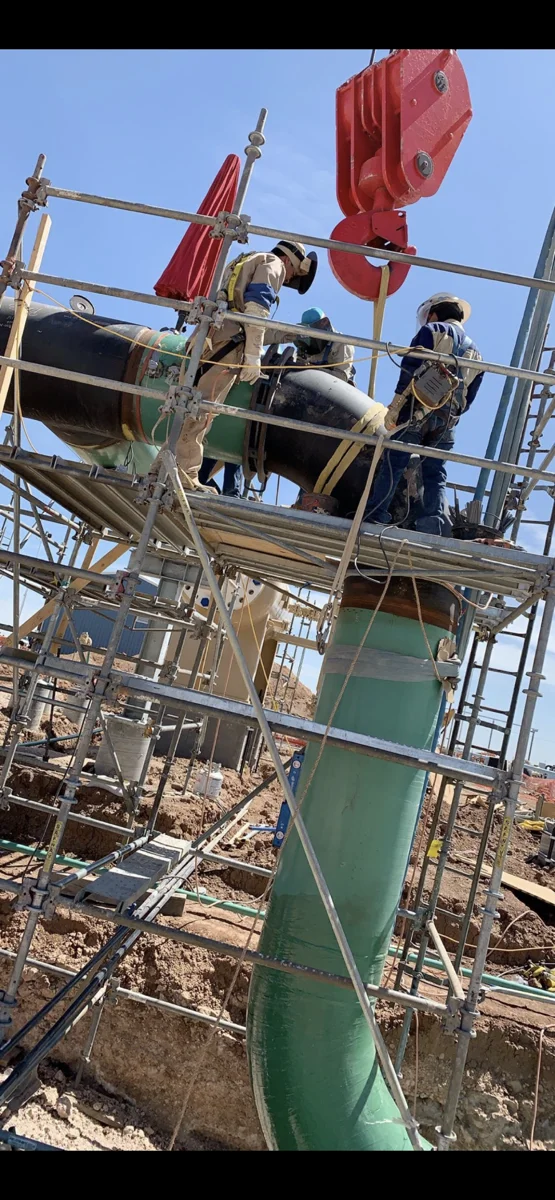Welding crew working on elevated industrial piping