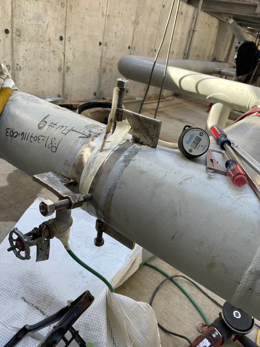 Close-up of an industrial piping assembly and pressure gauge